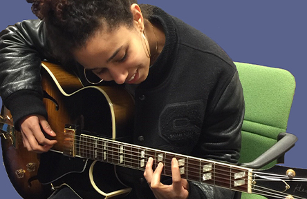 Artist Yanina playing music on guitar