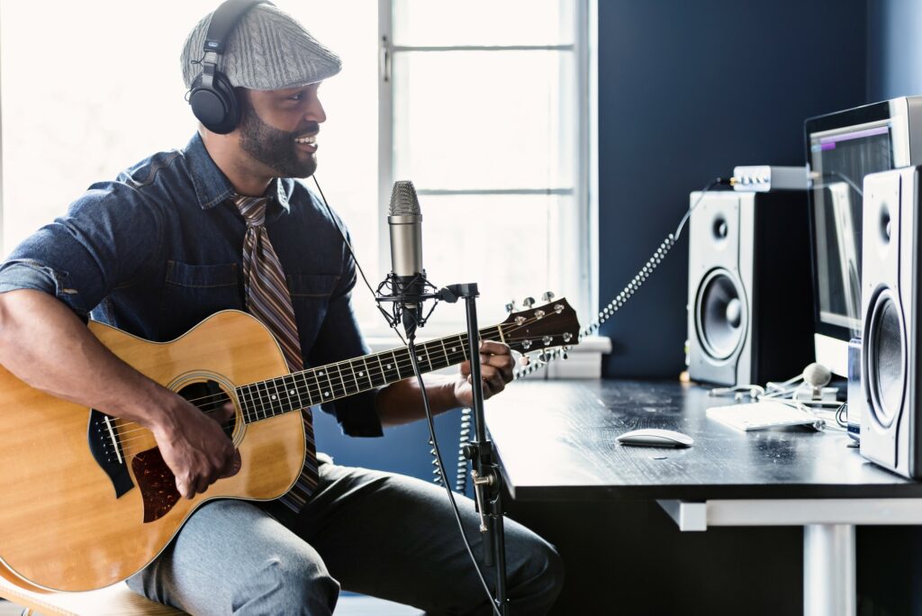 Musician with guitar recording music for the article: Top 13 Music Engineering Tips For Home Studio Recording