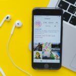 Phone with earphones and Instagram profile for Best Practices For Instagram Ads For Musicians article