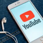 YouTube logo on mobile phone for YouTube Music Ad Strategies For Musicians article