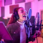 Female musician recording vocals using the best apps for making music