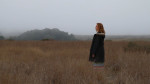 Musician standing in field for record release